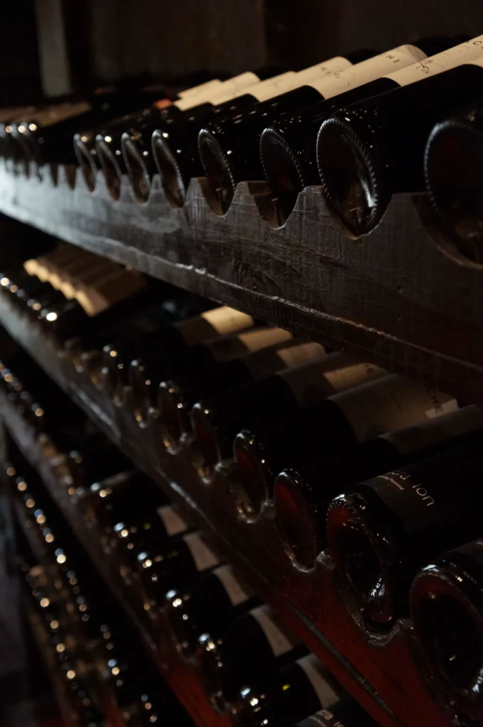 Bouteilles de vin alignées dans un casier en bois - Concept de cave à vin ambulante et wine truck Vin & Van dans le Calvados.